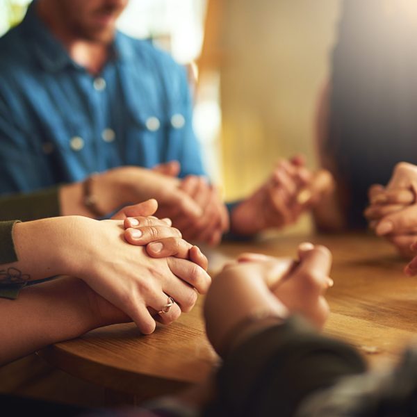 group of people holding hands to pray